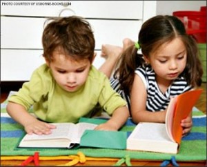 A posed photo of two preschool-age kids reading much bigger books than they should. Today’s young kids are not always given the room that they should be given to learn creatively.