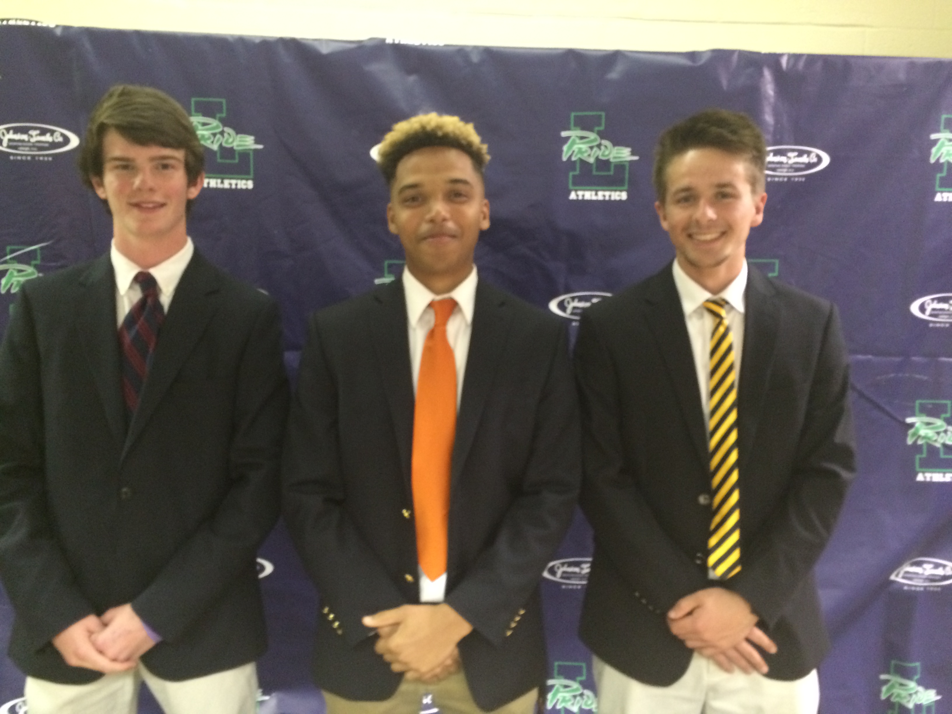 Three senior lacrosse players sign their letters of intent